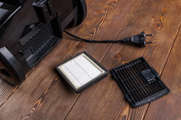 Removed exhaust rectangular HEPA - high-efficiency particulate air - filter of black vacuum cleaner on wooden surface — Stock Photo, Image