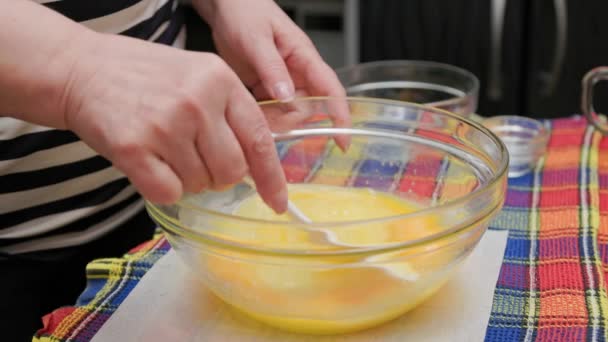 Senior kavkazská žena míchání sladké tekuté těsto v misce s bílou plastovou špachtlí — Stock video