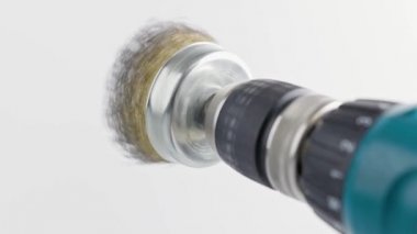 Beyaz arka planda dönen çelik fırçalı el matkabı