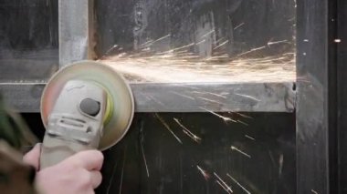 Kafkasya el temizliği, kaynak makinesiyle uzun kıvılcımlar ve yavaş çekim izleriyle kaynaklı metal inşaatında bir disk.