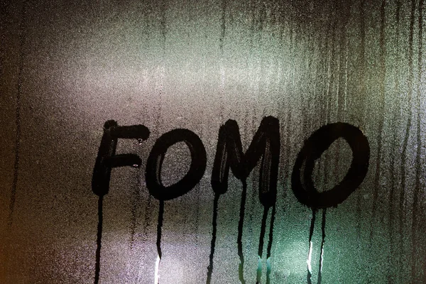 単語FOMO -行方不明者の恐怖-夜ぬれた窓ガラスの表面に手書き — ストック写真