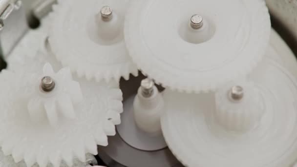 Five plastic gears rotate in mutual mesh inside a small reduction gear — Stock Video