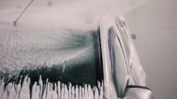 Abstract car washing at self-service station. Washing process with high pressure nozzle. Close-up with selective focus and slow motion. — Stock Video