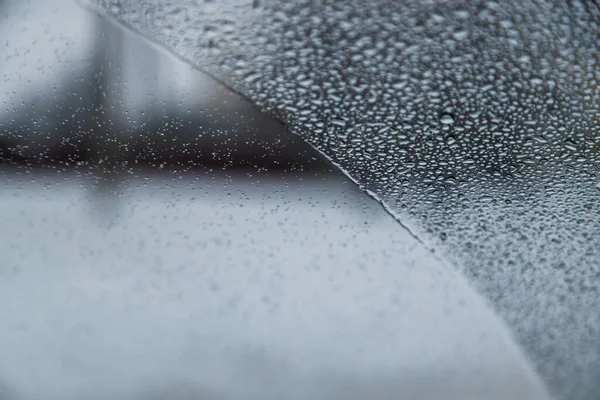 Vått vindruta fordon glas täckt med vatten droppar delvis torkas, suddig mulet väder i bakgrunden — Stockfoto