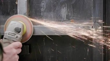 Kafkasya el temizliği, kaynak makinesiyle uzun kıvılcımlar ve yavaş çekim izleriyle kaynaklı metal inşaatında bir disk.