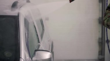 self-servis istasyonunda soyut araba yıkama. Yüksek basınç hortumuyla yıkama işlemi. Seçici odak ve yavaş çekim ile yakın çekim.