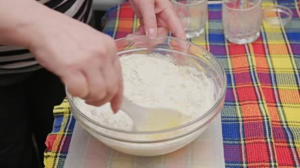 Senior caucasian woman stirring sweet liquid dough in the bowl with white plastic spatula — Stock Video