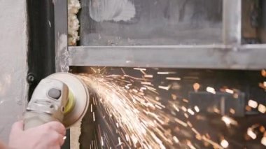 Kafkasya el temizliği, kaynak makinesiyle uzun kıvılcımlar ve yavaş çekim izleriyle kaynaklı metal inşaatında bir disk.