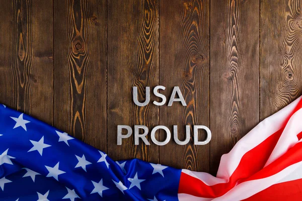 Palabras EE.UU. orgulloso establecido con letras de metal de plata en la superficie de madera marrón con la bandera de Estados Unidos de América — Foto de Stock