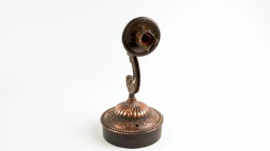 fake bronze sconce spinning on turning table on white background