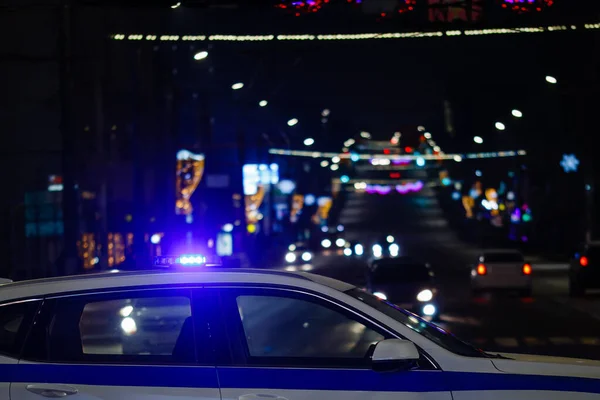 Полицейская машина с огнями в ночном городе, вид сбоку крупным планом с избирательным фокусом — стоковое фото