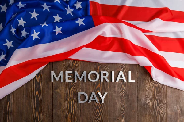 Les mots jour commémoratif posé avec des lettres en métal argenté sur la surface de la planche en bois avec drapeau américain froissé — Photo