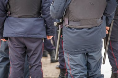 russian police officer with black rubber tonfa baton hanging on his belt