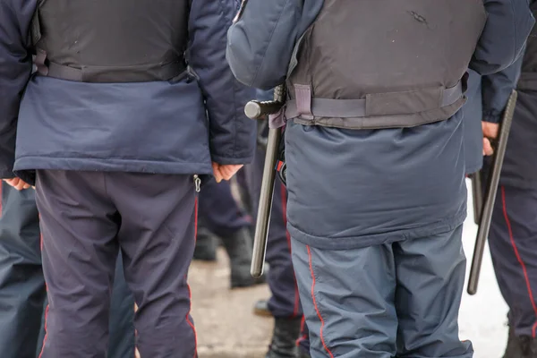 Russian police officer with black rubber tonfa baton hanging on his belt — Stockfoto