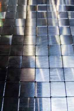 shiny steel machined blocks pavement surface background - close-up with selective focus and blur