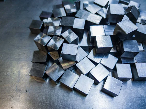 Pile of small machined shiny steel cubes on metal surface — Zdjęcie stockowe