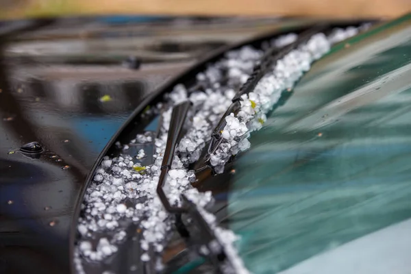Piccole palle di ghiaccio grandine sul cofano dell'auto nera dopo la forte tempesta estiva — Foto Stock