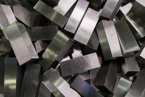 A pile of shiny faceted steel blocks - full frame close-up with selective focus — Stock Photo, Image