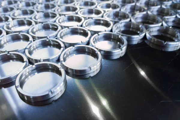 Shiny metal rings after turning and milling, silver colored parts on flat steel surface close-up full frame background — Fotografia de Stock