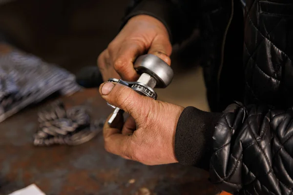 Dirty hands of caucasian car technician holding silver tool and wrench — Stockfoto