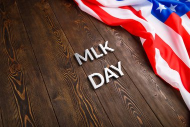 MLK günü, ahşap yüzeyde gümüş metal harflerle ve buruşuk Amerikan bayrağıyla yazıldı.