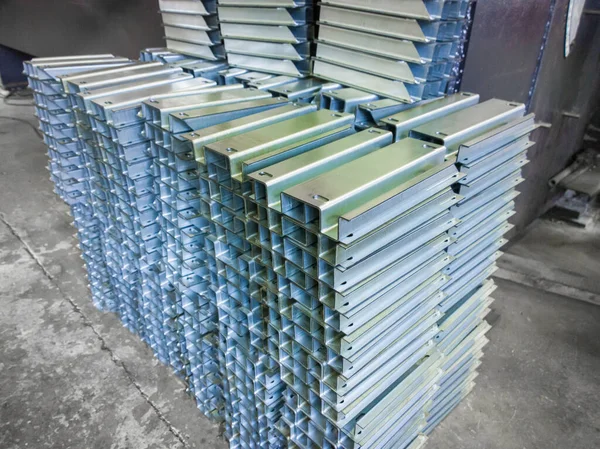 Stacks of profile bent sheet metal parts on factory floor — Stock Fotó