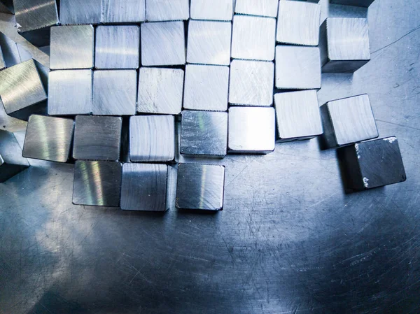 Pile of small machined shiny steel cubes on metal surface — Stockfoto