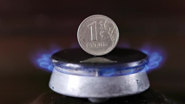 Gas stove burner with russian ruble standing vertically on top, burning gas — Stock Video