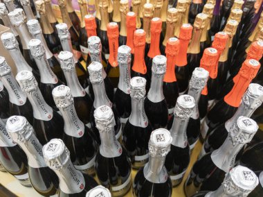 many bottles of champagne in a grocery store closeup with selective focus and wide angle