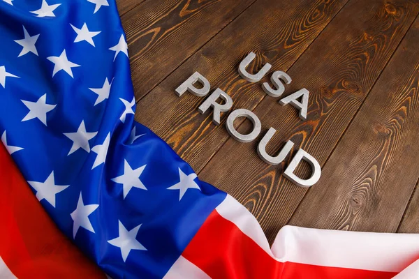 Palabras EE.UU. orgulloso establecido con letras de metal de plata en la superficie de madera marrón con la bandera de Estados Unidos de América — Foto de Stock