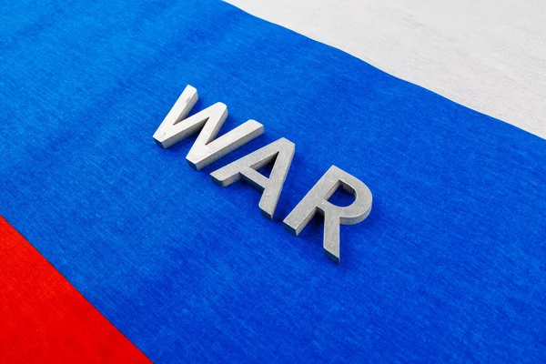 The word war laid with silver metal letters on Russian Federation tricolor flag — Stock Fotó