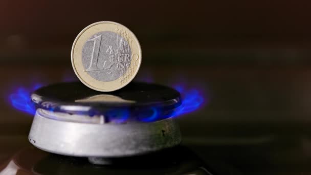 Газовая плита горелка с монетой в один евро, стоящей вертикально на вершине, горящий газ — стоковое видео