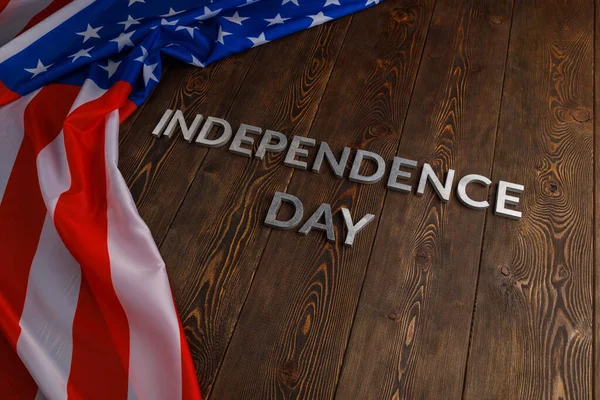 The words independence day laid on brown wooden planks surface with crumpled united states of america flag — Stock Photo, Image