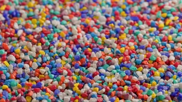 Crushed colored stones on flat surface, slowly spinning, loopable closeup — Stockvideo