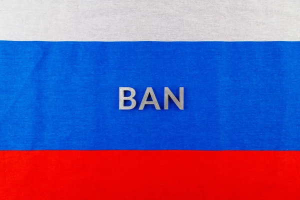 The word ban laid with silver metal letters over fabric Russian Federation flag — 스톡 사진
