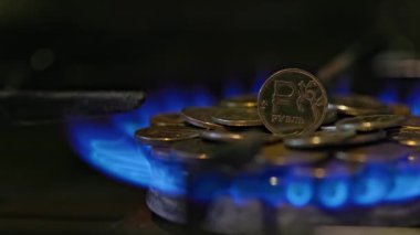 gas stove burner with russian ruble coins on top, burning gas