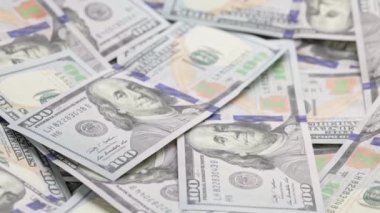 slowly roataing background of us dollar banknotes scattered on flat surface