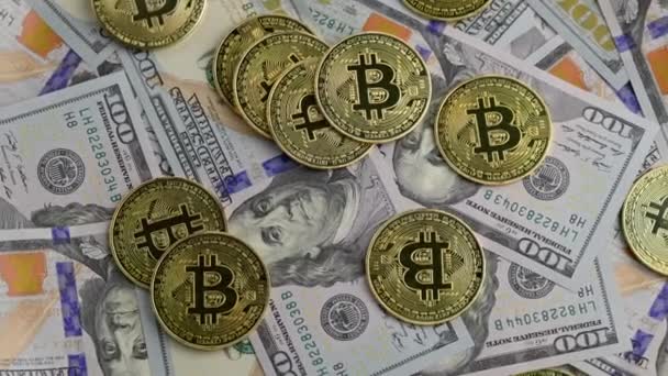 Rotating bitcoin coins scattered over US dollar banknotes, closeup — Vídeo de Stock