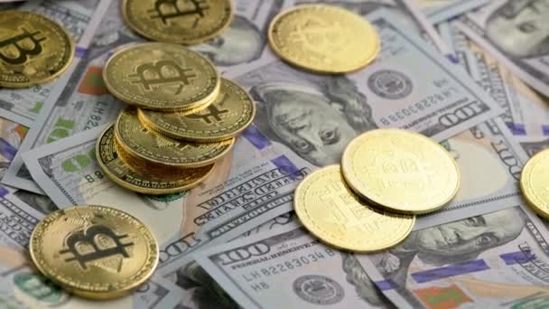 Περιστρεφόμενα κέρματα bitcoin διάσπαρτα σε τραπεζογραμμάτια δολαρίων ΗΠΑ, closeup — Αρχείο Βίντεο