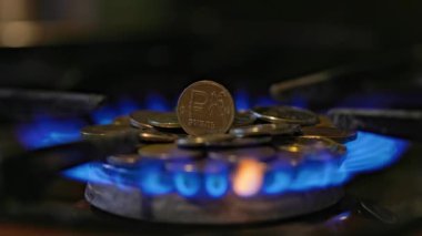 gas stove burner with russian ruble coins on top, burning gas