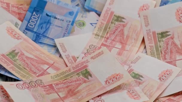 ロシアのルーブル紙幣が平面に散在する背景をゆっくりと回転させ — ストック動画