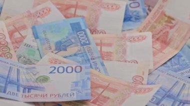 slowly roataing background of russian ruble banknotes scattered on flat surface
