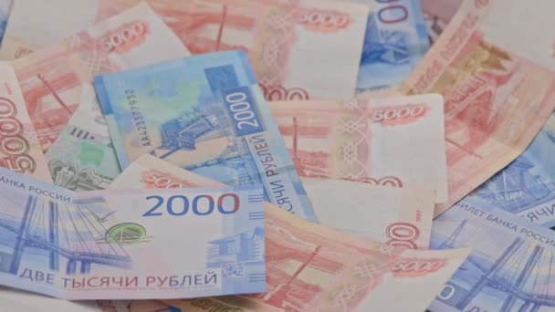 Slowly roataing background of russian ruble banknotes scattered on flat surface — Wideo stockowe