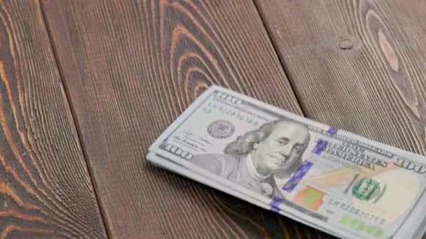 Stack of US dollar banknotes dropping on wooden surface and bouncing — Stok video