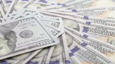 slowly roataing background of us dollar banknotes scattered on flat surface