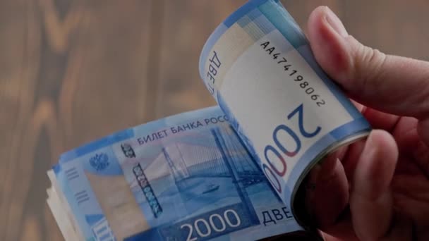 Caucasian hand checking small stack of russian ruble banknotes — Stockvideo