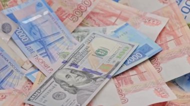 slowly roataing background of russian ruble banknotes with us dollar banknote