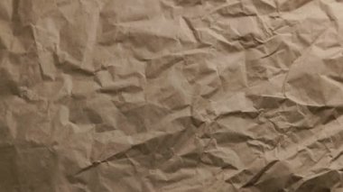 looped spinning close-up full-frame background of crumpled brown craft paper