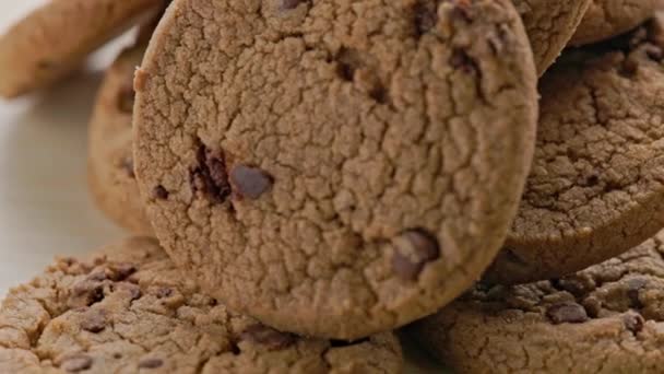 Round chip cake cookies with chocolate on white surface slow rotating — Stockvideo