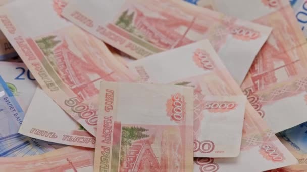 ロシアのルーブル紙幣が平面に散在する背景をゆっくりと回転させ — ストック動画
